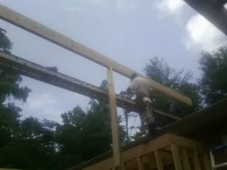 Carpenter setting a ridge beam over a new addition frame — Ice Dam Removal by Roofing Brothers in Zumbrota