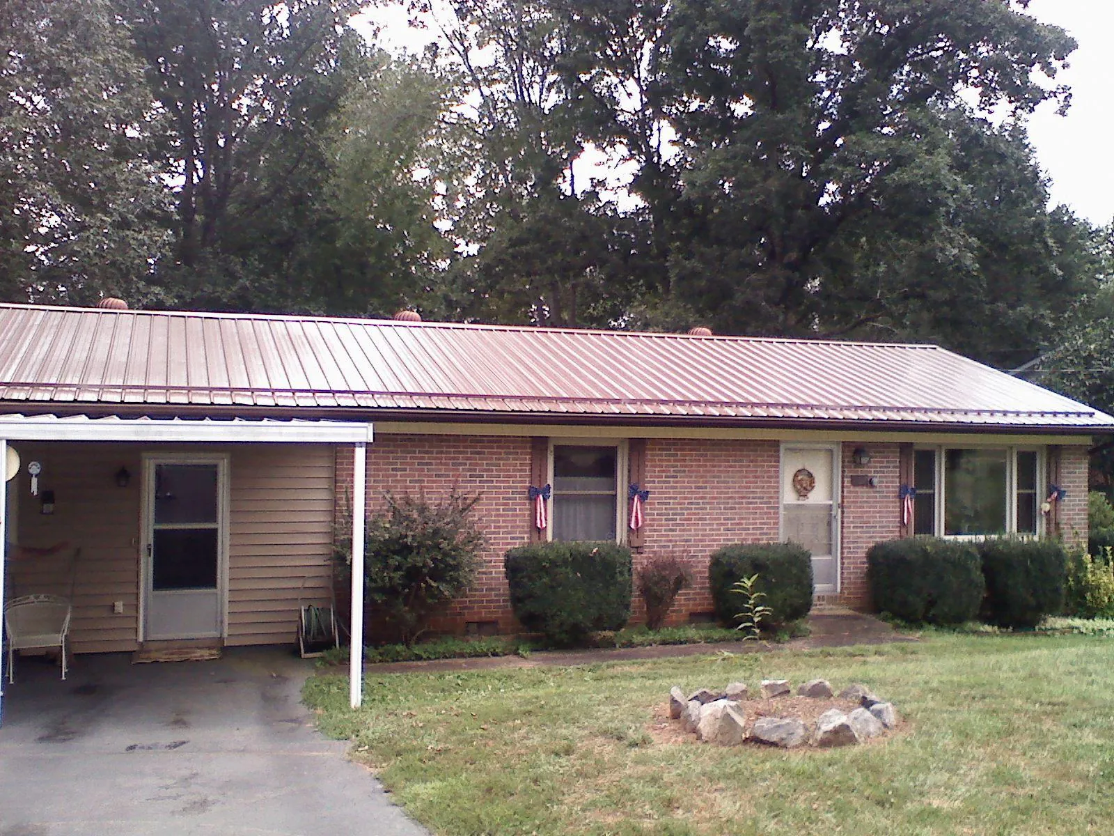 Bronze metal roof and carport on a brick ranch home — Roof Repair work by our crew in Zumbrota